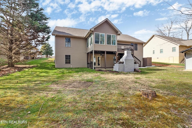 back of property with a lawn and a deck