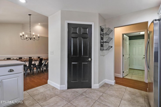 hallway featuring recessed lighting, a chandelier, baseboards, and light tile patterned flooring