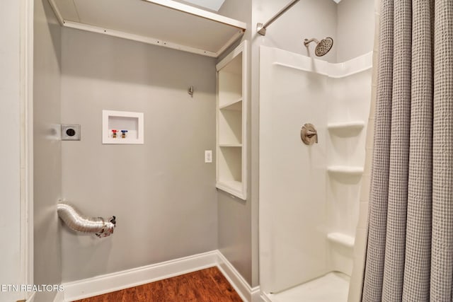 bathroom featuring baseboards, a shower with curtain, and wood finished floors