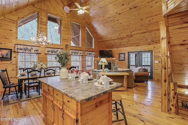 kitchen with a wealth of natural light, wood ceiling, wooden walls, and light hardwood / wood-style floors