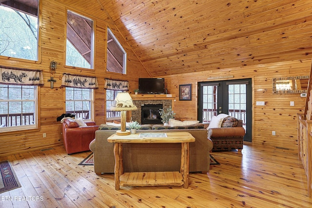 living room featuring french doors, a healthy amount of sunlight, high vaulted ceiling, and light hardwood / wood-style flooring