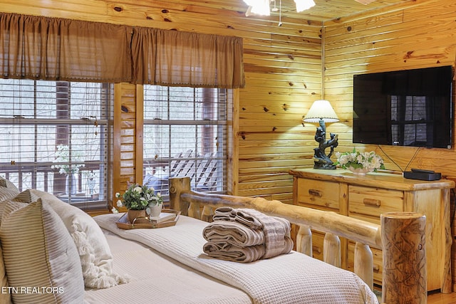 living area featuring ceiling fan and wood walls