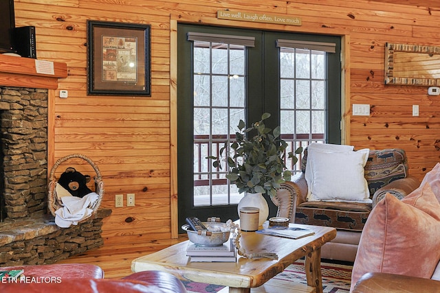 living room with french doors, hardwood / wood-style floors, and wood walls