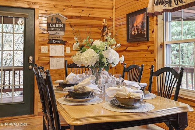 dining room featuring hardwood / wood-style flooring and wood walls