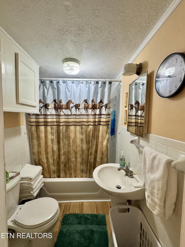 full bathroom featuring sink, tile walls, shower / bath combination with curtain, crown molding, and a textured ceiling