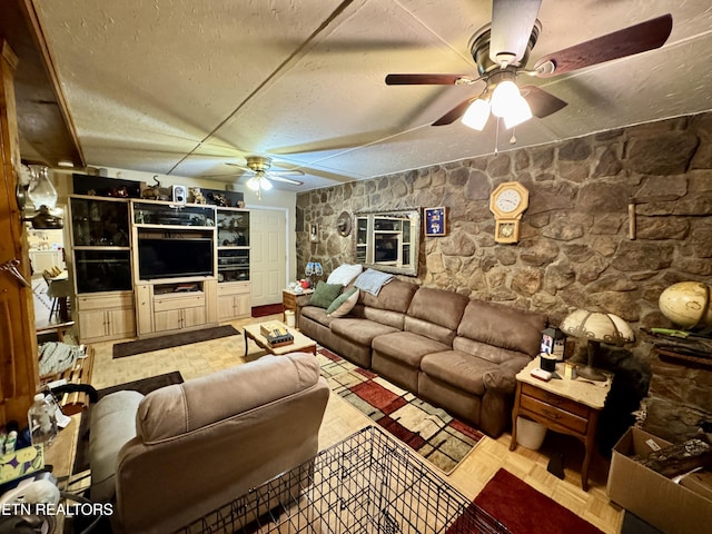 living room with ceiling fan and a textured ceiling