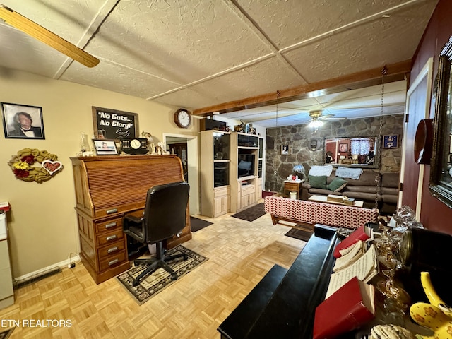 office space with ceiling fan, a paneled ceiling, and light parquet floors