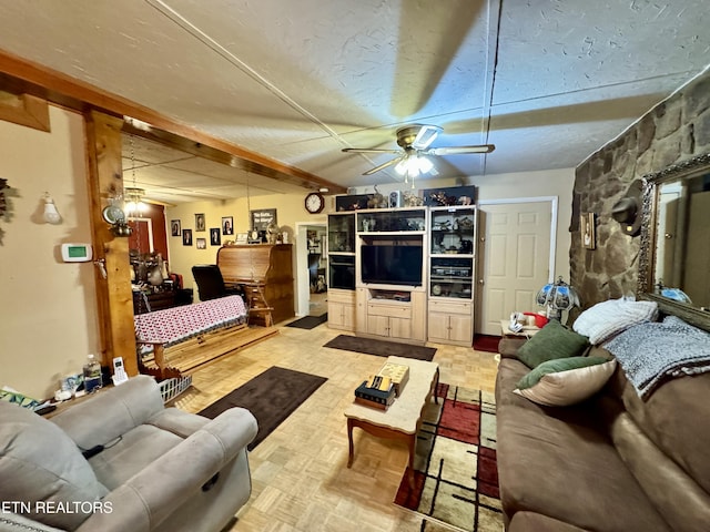 living room featuring beam ceiling, light parquet flooring, a textured ceiling, and ceiling fan