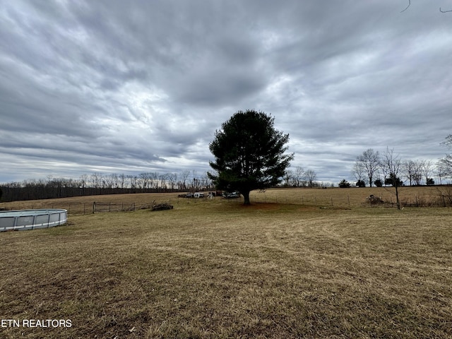 view of yard featuring a rural view and a fenced in pool