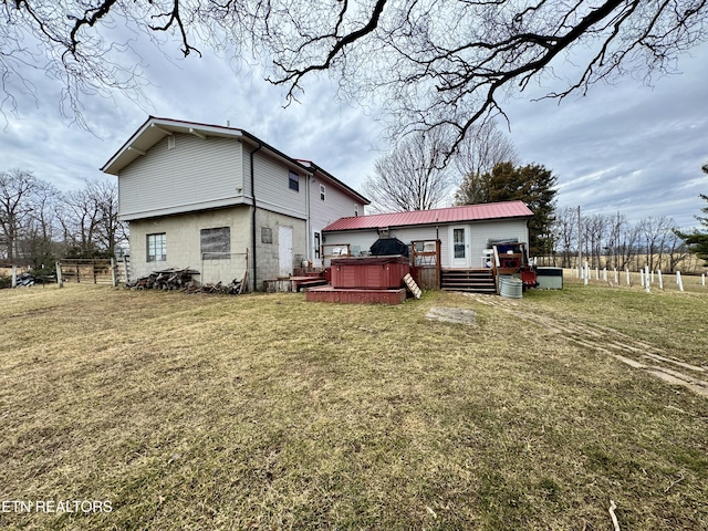 rear view of property featuring a lawn and a deck