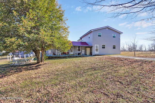 back of house with a yard and covered porch