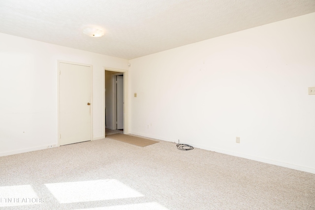 unfurnished room with a textured ceiling and carpet