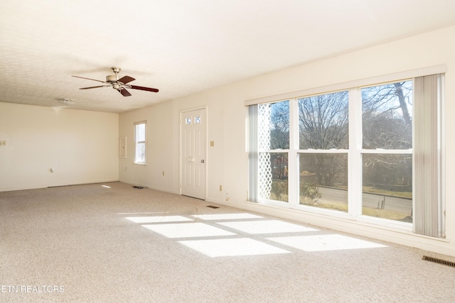 unfurnished living room featuring light colored carpet and ceiling fan