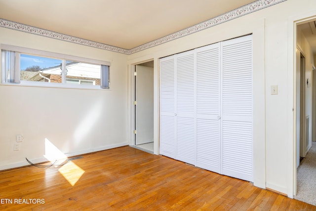 unfurnished bedroom featuring light wood-type flooring and a closet