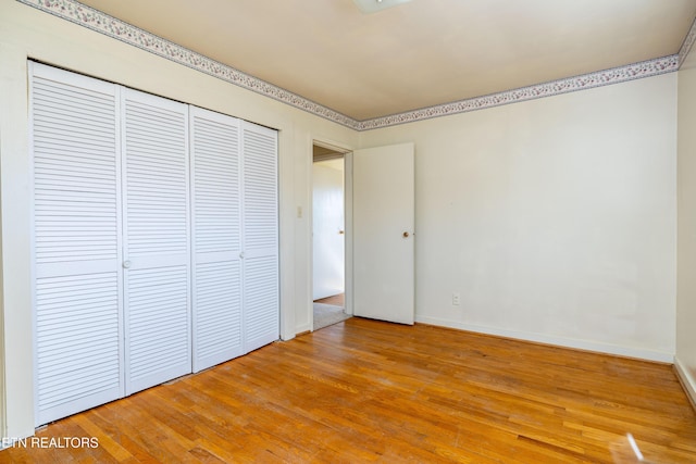 unfurnished bedroom featuring light wood-type flooring and a closet