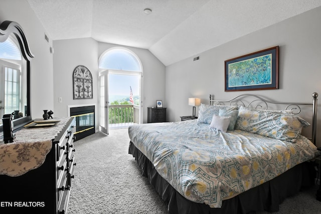 carpeted bedroom with vaulted ceiling, access to outside, and a textured ceiling