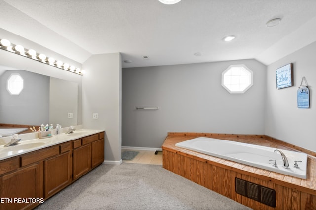 bathroom with vanity, lofted ceiling, and a washtub