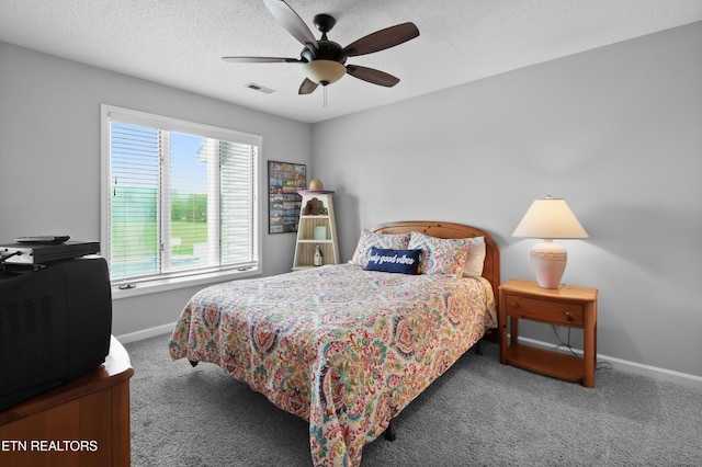 carpeted bedroom with ceiling fan and a textured ceiling