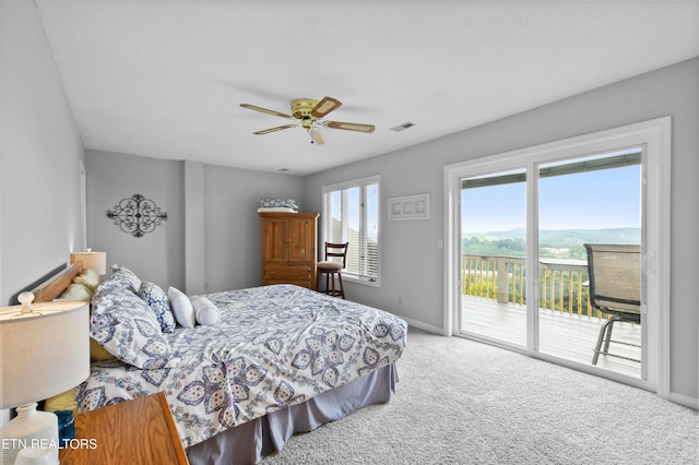 bedroom featuring access to exterior, a mountain view, ceiling fan, and carpet