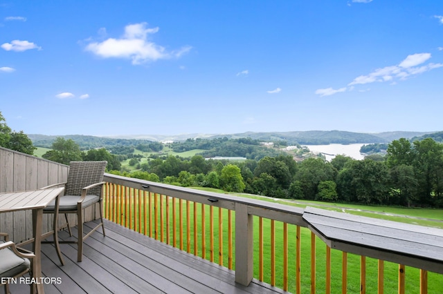 wooden terrace featuring a yard and a mountain view