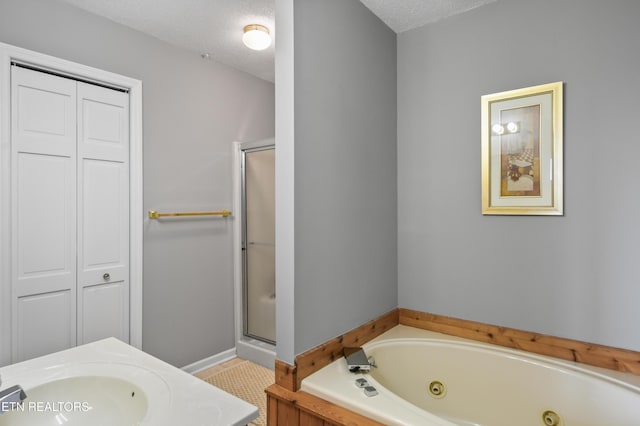 bathroom with sink, a textured ceiling, and separate shower and tub