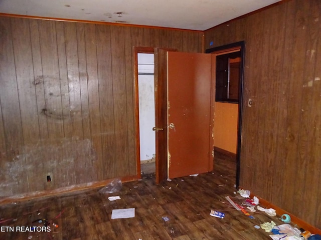 interior space with dark wood-type flooring and wooden walls