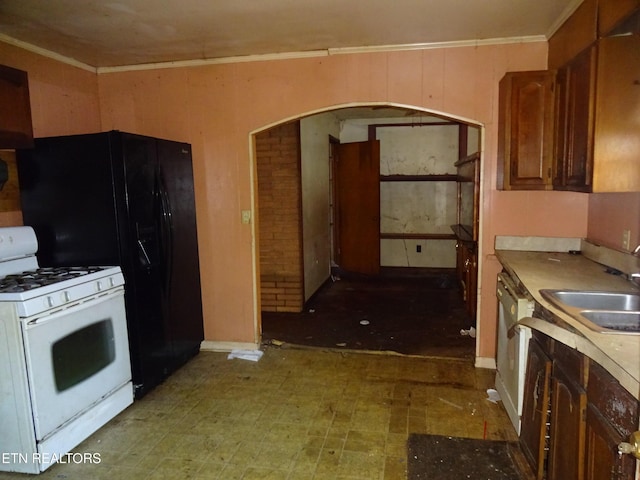 kitchen with crown molding, sink, white appliances, and wood walls