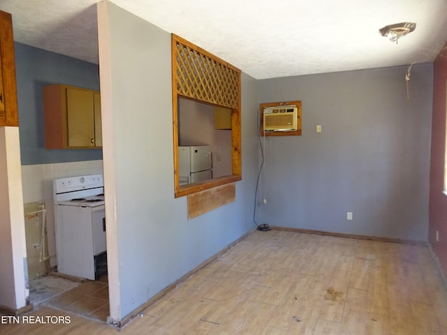 unfurnished room featuring an AC wall unit and light wood-style flooring