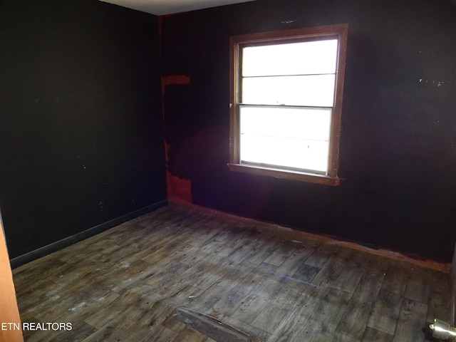 unfurnished room with baseboards and wood finished floors