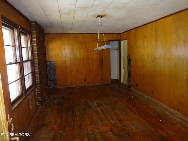 empty room with dark wood finished floors and wooden walls