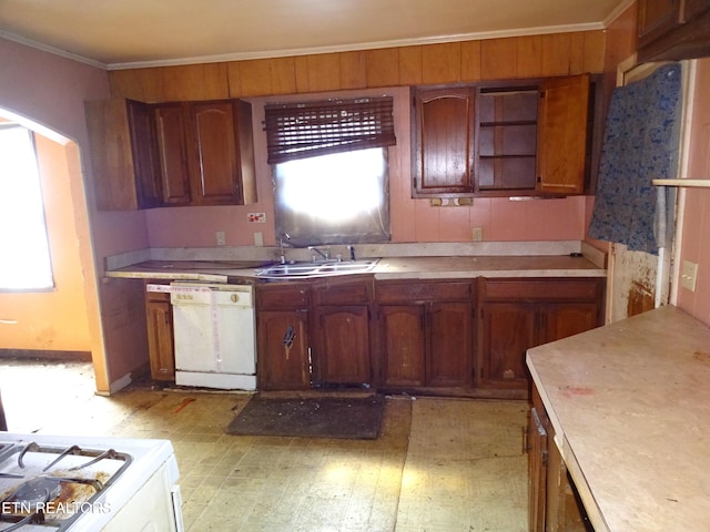 kitchen with arched walkways, crown molding, light countertops, a sink, and dishwasher