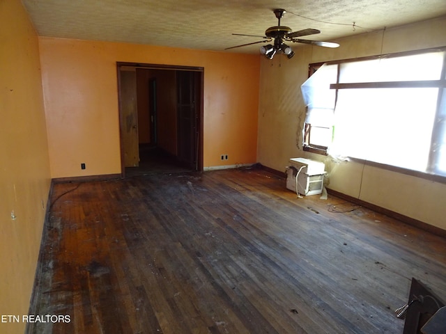 empty room with dark wood-type flooring, baseboards, and a ceiling fan