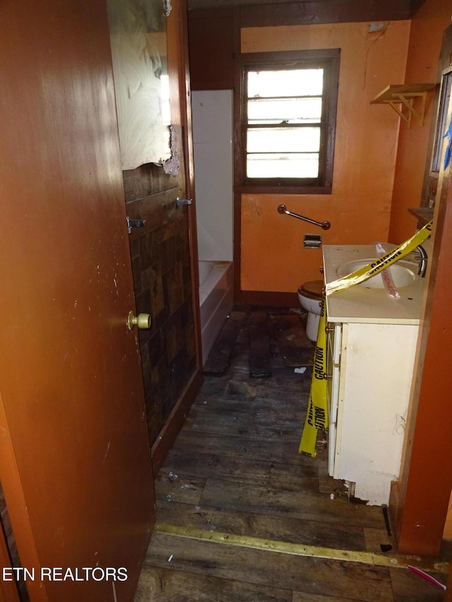 corridor featuring dark wood-style flooring and a sink