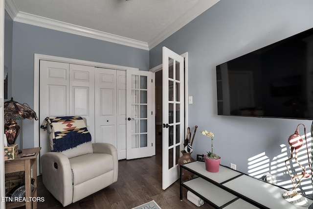 sitting room with dark wood-type flooring, ornamental molding, and french doors