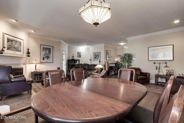 dining area with wood-type flooring and ornamental molding