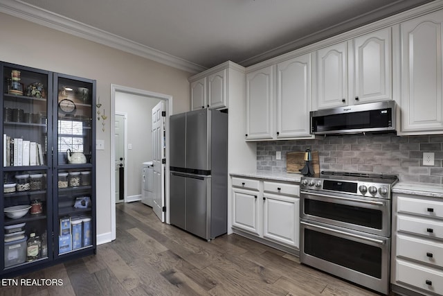 kitchen with crown molding, appliances with stainless steel finishes, white cabinetry, backsplash, and dark hardwood / wood-style floors