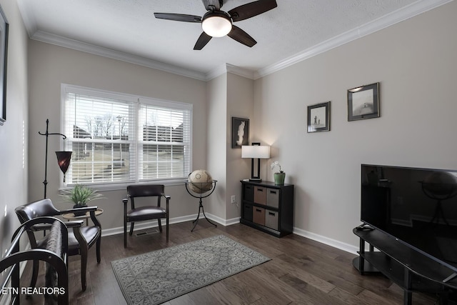 sitting room with ornamental molding, dark wood-type flooring, and ceiling fan