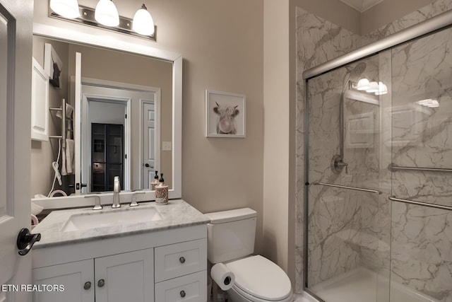 bathroom featuring vanity, toilet, and a shower with door