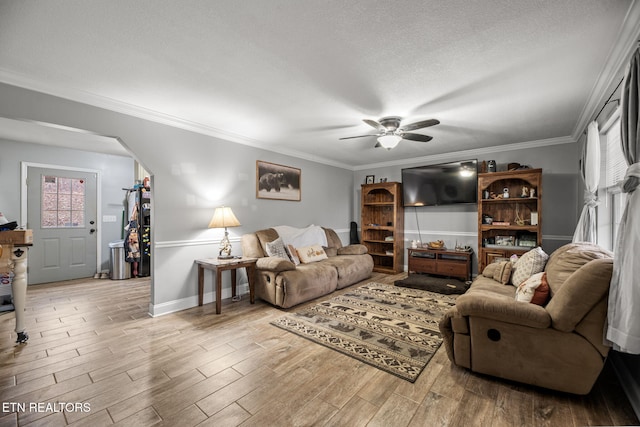 living room with crown molding, a textured ceiling, and light wood-type flooring