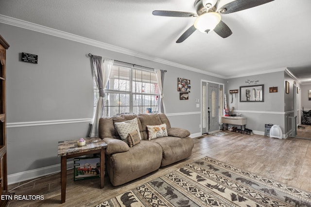 living room with baseboards, a ceiling fan, wood finished floors, and crown molding