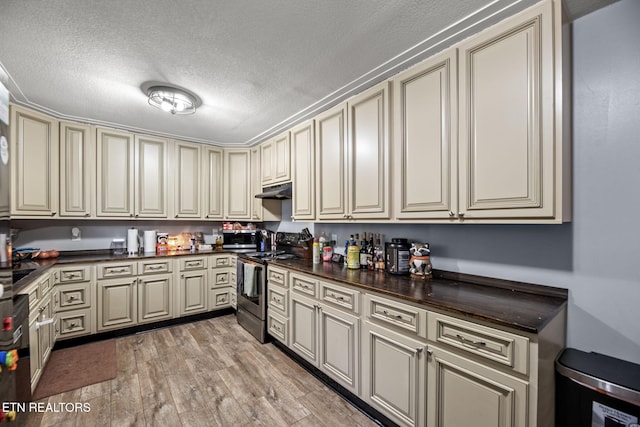 kitchen with dark countertops, stainless steel electric stove, and cream cabinetry