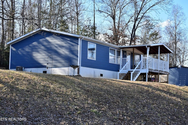 exterior space featuring a front lawn, central air condition unit, and a porch