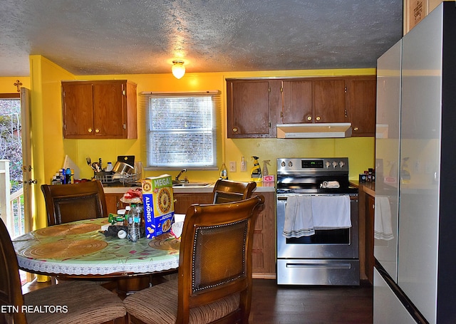 kitchen featuring stainless steel appliances, sink, a textured ceiling, and dark hardwood / wood-style flooring