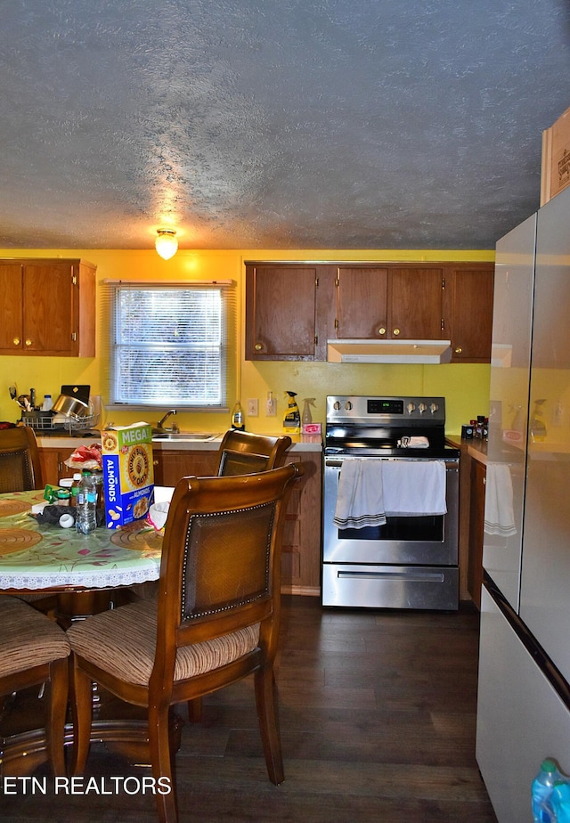 kitchen with dark wood-type flooring, stainless steel electric range oven, sink, and a textured ceiling