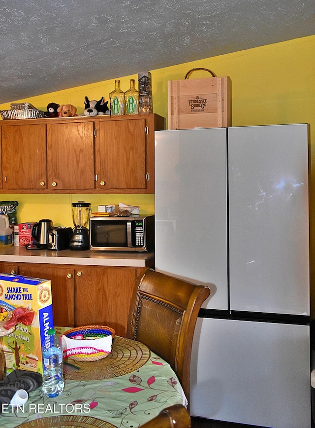 kitchen featuring refrigerator and a textured ceiling