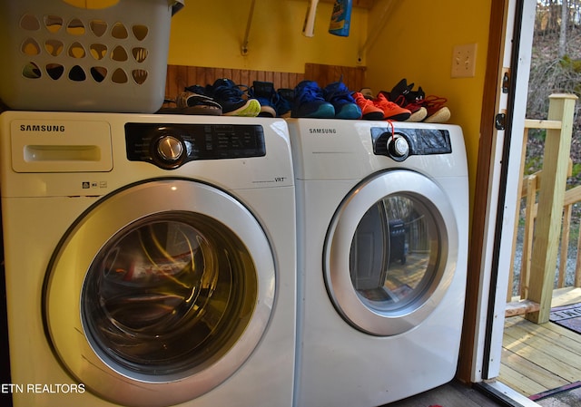 clothes washing area with washing machine and clothes dryer and hardwood / wood-style floors