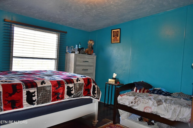 bedroom with wood-type flooring and a textured ceiling