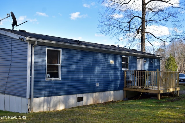 exterior space with a wooden deck and a lawn