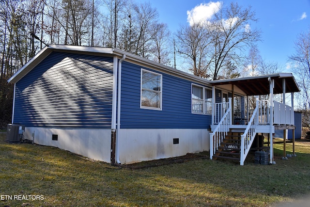 view of side of property featuring a yard and central AC