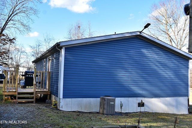 view of side of property featuring a deck and central AC unit